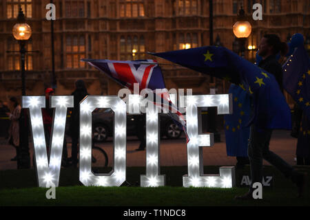 Anti-Brexit Demonstranten mit einem beleuchteten Schild 'Lasst uns Stimme" außerhalb des Houses of Parliament, London, an dem Tag, an dem die Abgeordneten aufgefordert werden, eine Reihe alternativer Brexit Optionen in Betracht zu ziehen, nachdem das Parlament die Kontrolle über den Commons Agenda eine Reihe von "probeabstimmungen "Force beschlagnahmt. Stockfoto