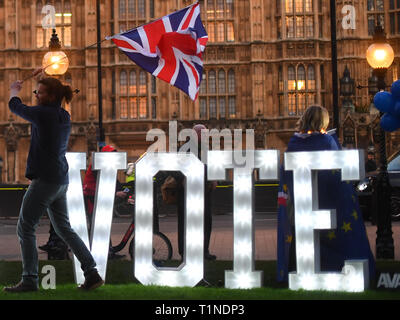 Anti-Brexit Demonstranten mit einem beleuchteten Schild 'Lasst uns Stimme" außerhalb des Houses of Parliament, London, an dem Tag, an dem die Abgeordneten aufgefordert werden, eine Reihe alternativer Brexit Optionen in Betracht zu ziehen, nachdem das Parlament die Kontrolle über den Commons Agenda zu einer Reihe von 'Probeabstimmungen 'force beschlagnahmt. Stockfoto