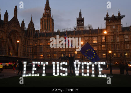 Anti-Brexit-Demonstranten mit einem beleuchteten Schild mit der Aufschrift „Lassen Sie uns abstimmen“ vor dem Londoner Parlamentsgebäude an dem Tag, an dem die Abgeordneten aufgefordert werden, eine Reihe alternativer Brexit-Optionen in Erwägung zu ziehen, nachdem das Parlament die Kontrolle über die Agenda des Unterhauses übernommen hat, um eine Reihe von indikativen Abstimmungen zu erzwingen. Stockfoto