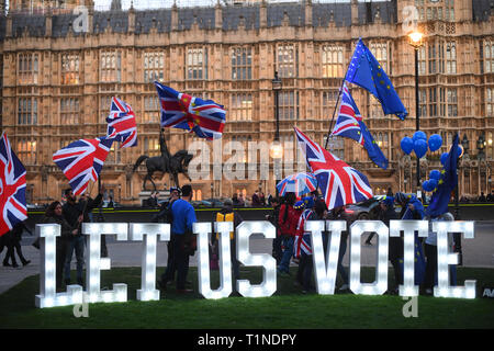 Anti-Brexit Demonstranten mit einem beleuchteten Schild 'Lasst uns Stimme" außerhalb des Houses of Parliament, London, an dem Tag, an dem die Abgeordneten aufgefordert werden, eine Reihe alternativer Brexit Optionen in Betracht zu ziehen, nachdem das Parlament die Kontrolle über den Commons Agenda eine Reihe von "probeabstimmungen "Force beschlagnahmt. Stockfoto