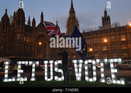 Anti-Brexit-Demonstranten mit einem beleuchteten Schild mit der Aufschrift „Lassen Sie uns abstimmen“ vor dem Londoner Parlamentsgebäude an dem Tag, an dem die Abgeordneten aufgefordert werden, eine Reihe alternativer Brexit-Optionen in Erwägung zu ziehen, nachdem das Parlament die Kontrolle über die Agenda des Unterhauses übernommen hat, um eine Reihe von indikativen Abstimmungen zu erzwingen. Stockfoto