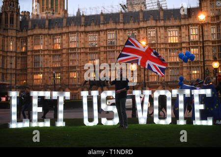 Anti-Brexit Demonstranten mit einem beleuchteten Schild 'Lasst uns Stimme" außerhalb des Houses of Parliament, London, an dem Tag, an dem die Abgeordneten aufgefordert werden, eine Reihe alternativer Brexit Optionen in Betracht zu ziehen, nachdem das Parlament die Kontrolle über den Commons Agenda zu einer Reihe von 'Probeabstimmungen 'force beschlagnahmt. Stockfoto