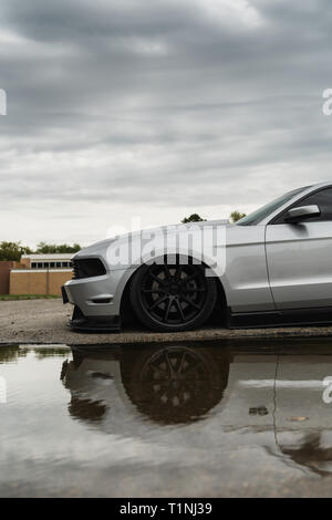 Silber American Muscle Car in Wasser bei bewölktem Himmel wider. Stockfoto