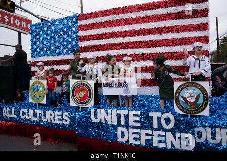 Kinder gekleidet in Militäruniformen Fahrt auf Float erkennen Filialen des US-Militärs während der Parade in der Innenstadt von Laredo, Texas. Stockfoto