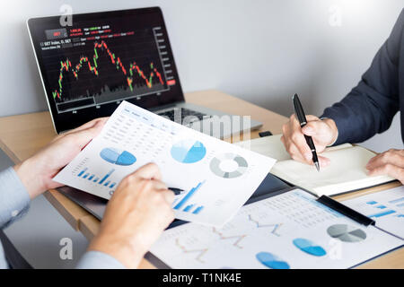 Die Unternehmer sprechen über Börse investieren Trading online Analyse ueber finanzielle Graph für Investitionszwecke Diskussion im Traders Büro Stockfoto