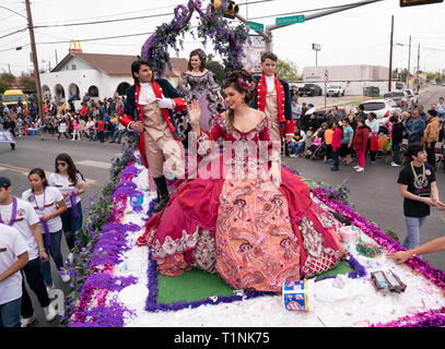 Lokale Debütantinnen und ihre Begleitpersonen tragen aufwendigen Kostümen, beim Reiten auf einem Float bei Washington's Birthday Celebration Parade in Laredo, TX USA Stockfoto