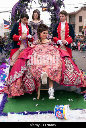 Lokale Debütantinnen und ihre Begleitpersonen tragen aufwendigen Kostümen, beim Reiten auf einem Float bei Washington's Birthday Celebration Parade in Laredo, TX USA Stockfoto