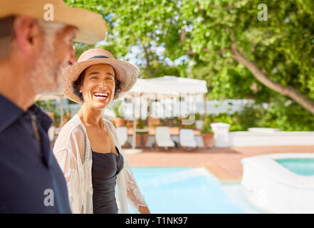 Glückliches junges Paar bei Sunny Resort Pool Stockfoto