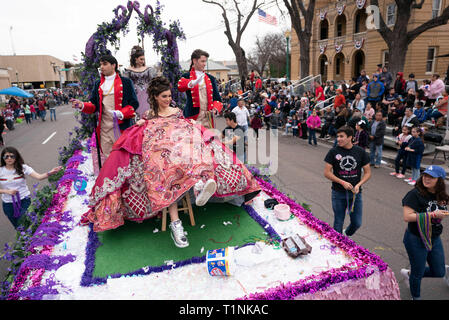 Lokale Debütantinnen und ihre Begleitpersonen tragen aufwendigen Kostümen, beim Reiten auf einem Float bei Washington's Birthday Celebration Parade in Laredo, TX USA Stockfoto