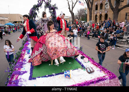 Lokale Debütantinnen und ihre Begleitpersonen tragen aufwendigen Kostümen, beim Reiten auf einem Float bei Washington's Birthday Celebration Parade in Laredo, TX USA Stockfoto