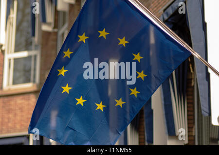 Fahne der Europäischen Union winken in den Wind mit einem Gebäude im Hintergrund Stockfoto