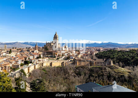 Segovia, Spanien: Blick von Juan II Tower im Winter der Alcazar in der Altstadt von Segovia und die Kathedrale mit dem schneebedeckten Sierra de Guadalajara Stockfoto