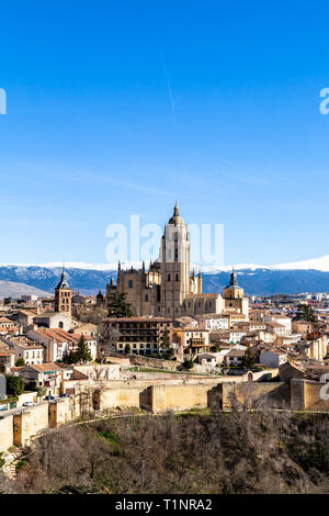 Segovia, Spanien: Blick von Juan II Tower im Winter der Alcazar in der Altstadt von Segovia und die Kathedrale mit dem schneebedeckten Sierra de Guadalajara Stockfoto