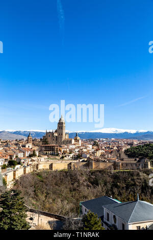 Segovia, Spanien: Blick von Juan II Tower im Winter der Alcazar in der Altstadt von Segovia und die Kathedrale mit dem schneebedeckten Sierra de Guadalajara Stockfoto