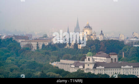 Lemberg, Ukraine - 1. September 2018: Nebligen Morgen in der Innenstadt von Rathausturm. Dächer der alten Stadt. Blick auf die Kirche der Hll. Olha und Stockfoto