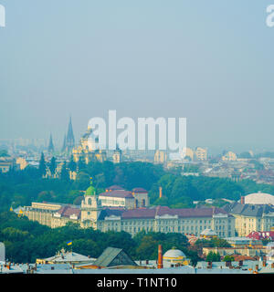 Lemberg, Ukraine - 1. September 2018: Nebligen Morgen in der Innenstadt von Rathausturm. Dächer der alten Stadt. Blick auf die Kirche der Hll. Olha und Stockfoto