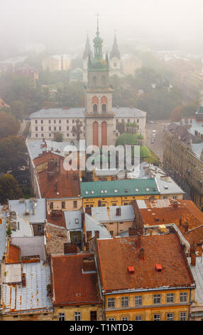 Lemberg, Ukraine - 1. September 2018: Nebligen Morgen in der Innenstadt von Rathausturm. 1352 oder Himmelfahrt Kirche Stockfoto