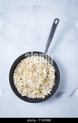 Raw Semmelbrösel in einer Pfanne mit einer Top Aussicht und einem weißen Marmor Hintergrund gedreht. Raw pangritata Italienische Semmelbrösel in einer Pfanne in der Mitte. Stockfoto