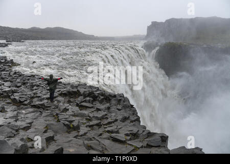 Touristische bewundernden Blick des fallenden Wassers der mächtigsten Wasserfall Europas - Dettifoss. Jokulsargljufur National Park, Island. Weiße Nächte anzeigen Stockfoto