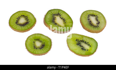 Grüne kiwi Scheiben. Fuzzy Kiwis. Actinidia deliciosa. Auf weissem Hintergrund. In Scheiben geschnitten Bio kiwis Gruppe close-up. Braune Haut, schwarze Samen. Stockfoto