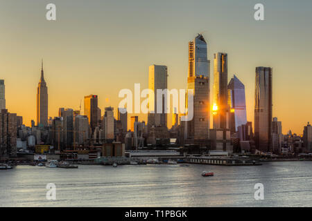 Das Sonnenlicht spiegelte sich bei Sonnenaufgang von der gemischt genutzten Hudson Yards-Entwicklung und anderen Gebäuden auf der Westseite von Manhattan in New York City wider. Stockfoto