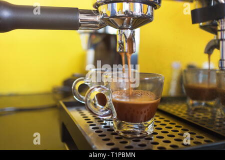 Kaffeemaschine bereitet frischen Kaffee und Gießen in cups im Cafe. Stockfoto