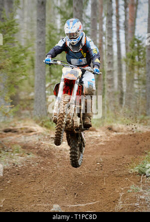 Motocross Fahrer springen mit dem Bike mit hoher Geschwindigkeit auf der Rennstrecke. Stockfoto