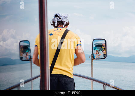 Surat Thai, Thailand - Januar 24, 2018: Touristen, die auf die Fähre nach Koh Samui und Koh Phangan Inseln. Mann, der auf dem Deck Stockfoto