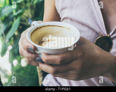 Close-up Frau Hände halten eine weiße heiße Tasse Kaffee im Cafe mit kopieren. Stockfoto
