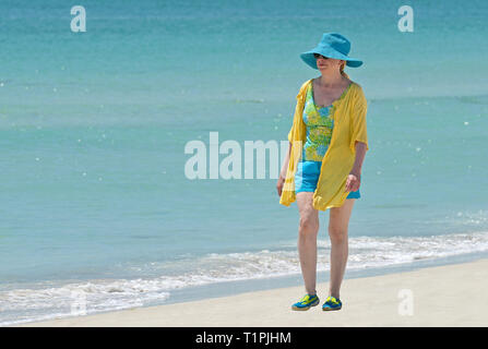 Attraktive, reife Frau zu Fuß am Strand in sehr modische Kleidung Stockfoto
