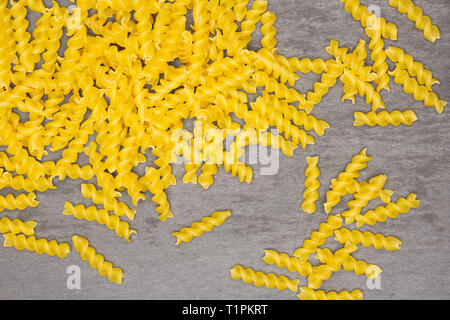 Viele Stücke von Raw italitan gelbe Nudeln torti flatlay am grauen Stein Stockfoto