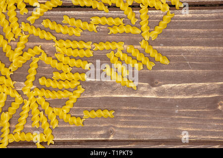 Viele Stücke von Raw italitan gelbe Nudeln torti flatlay auf braunem Holz Stockfoto