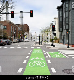 Geschützt Radweg und Kreuzung Kennzeichnungen auf der Straße der Stadt. Fahrrad Ampeln und Schilder gemalt auf Grün und Weiß Stockfoto