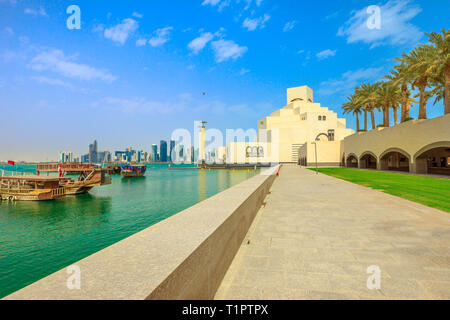 Doha Strandpromenade mit Palmen und West Bay Skyline entlang der Corniche in der katarischen Hauptstadt mit Dhow Hafen an einem sonnigen Tag. Doha in Katar. Naher Osten Stockfoto