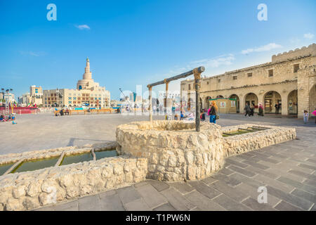 Doha, Katar - Februar 20, 2019: alter Brunnen Brunnen, Wahrzeichen im Souq Waqif und Fanar Islamischen Kulturzentrum mit Moschee und Minarett auf Stockfoto