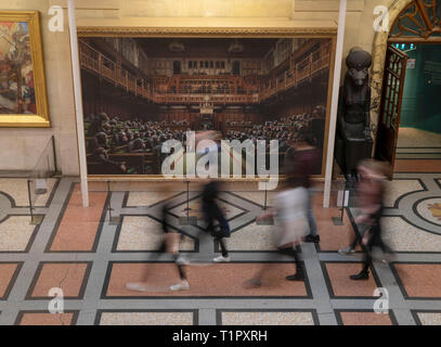 Die Passanten auf dem Gemälde 'Dentwickelte sich das Parlament durch die Graffiti Künstler Banksy, der auf der Bristol Museum ist. Stockfoto