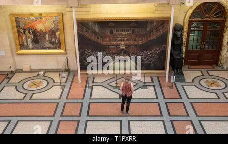 Ein Passant auf dem Gemälde "Das Parlament entwickelt" durch die Graffiti Künstler Banksy, der auf der Bristol Museum ist. Stockfoto