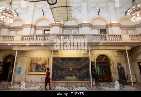 Ein Passant auf dem Gemälde "Das Parlament entwickelt" durch die Graffiti Künstler Banksy, der auf der Bristol Museum ist. Stockfoto