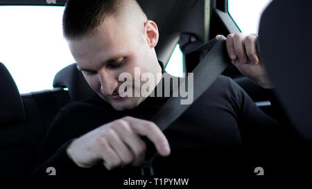 Selbstbewussten jungen stilvolle Geschäftsmann, der in seinem Auto Befestigung des Sicherheitsgurts, sicheres Fahren Konzept Stockfoto