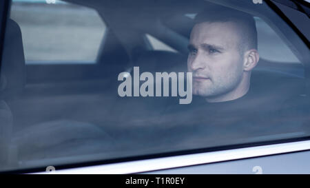 Ernste und konzentrierte Geschäftsmann auf dem Rücksitz im Auto sitzen Stockfoto