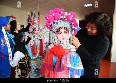 Peking, China. 27 Mär, 2019. Little Darsteller erhalten ihr Make-up mit Hilfe ihrer Lehrer an einer Grundschule in Jiashan, der ostchinesischen Provinz Zhejiang, am 27. März 2019, die Welt Theater Tag. Credit: Ning Wenwu/Xinhua/Alamy leben Nachrichten Stockfoto