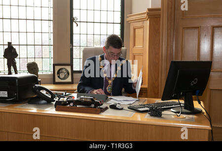 Derry, Großbritannien. 20 Mär, 2019. John Boyle, Bürgermeister von Derry, arbeitet in seinem Büro in Derry, eine Grenzstadt in Nordirland, Vereinigtes Königreich, am 20. März 2019. Die sich abzeichnende Möglichkeit einer harten irischen Grenze, die von Brexit Ursachen Qual zu Menschen in Derry, eine Grenzstadt in Nordirland noch nicht vertraut mit dunklen Tagen von Spaltung und Gewalt erstellt werden konnte. Mit Spotlight: Nordirland Stadt vorsichtig von möglich, die Grenze als Brexit Webstühle Credit: Han Yan/Xinhua/Alamy leben Nachrichten Stockfoto