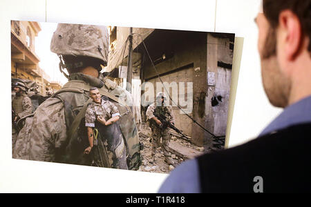 27. März 2019, Nordrhein-Westfalen, Köln: ein Mann betrachtet ein Foto von Anja Niedringhaus aus dem Irak. Die Ausstellung "Anja Niedringhaus - Bilderkriegerin" können ab dem 29. März des auf das Käthe Kollwitz Museum in Köln bis zum 30. Juni 2019 gesehen werden. Foto: Oliver Berg/dpa Stockfoto