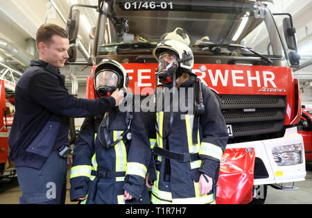 Rostock, Deutschland. 28. März, 2019. Am Girls' Day bei der Feuerwehr der Hansestadt Marcel Günther, fire Master, zeigt die Schüler Kathi (16) (L-R) und Pia (17) Wie schwer die Ausrüstung der Feuerwehr ist. Mehr als 2000 Schülerinnen sind auf der diesjährigen "Girls' Day" in Unternehmen und Institutionen in Mecklenburg-Vorpommern erwartet, technische Berufe zu erkunden, unter anderem. Quelle: Bernd Wüstneck/dpa/Alamy leben Nachrichten Stockfoto