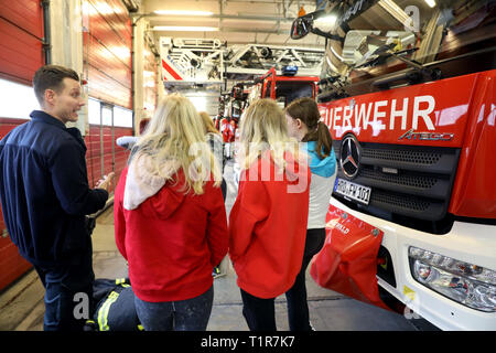 Rostock, Deutschland. 28. März, 2019. Marcel Günther, fire Master, erklärt der Fahrzeuge und die Technologie an die Schüler einer neunten Klasse am "Girls' Day" bei der Berufsfeuerwehr der Hansestadt. Mehr als 2000 Schülerinnen sind auf der diesjährigen "Girls' Day" in Unternehmen und Institutionen in Mecklenburg-Vorpommern erwartet, technische Berufe zu erkunden, unter anderem. Quelle: Bernd Wüstneck/dpa/Alamy leben Nachrichten Stockfoto