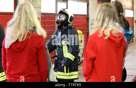 Rostock, Deutschland. 28. März, 2019. Am "Girls' Day" bei der Berufsfeuerwehr der Hansestadt, die Schülerinnen und Schüler einer neunten Klasse erfahren Sie, wie die schwere Ausrüstung der Feuerwehrleute ist. Mehr als 2000 Schülerinnen sind auf der diesjährigen "Girls' Day" in Unternehmen und Institutionen in Mecklenburg-Vorpommern erwartet, technische Berufe zu erkunden, unter anderem. Quelle: Bernd Wüstneck/dpa/Alamy leben Nachrichten Stockfoto