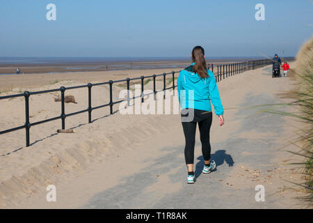 Crosby, Merseyside. 28. März, 2019. UK Wetter. Hellen sonnigen Start in den Tag an der Küste als lokaler Bewohner genießen Sie Frühling Wetter auf der Küstenpromenade. Kredit. MediaWorldImages/AlamyLiveNews. Stockfoto