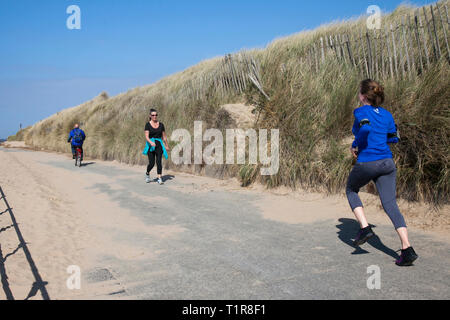 Crosby, Merseyside. 28. März, 2019. UK Wetter. Hellen sonnigen Start in den Tag an der Küste als lokaler Bewohner genießen Sie Frühling Wetter auf der Küstenpromenade. Kredit. MediaWorldImages/AlamyLiveNews. Stockfoto