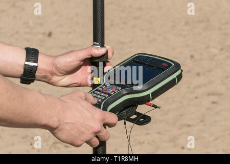 Strandbefragung durch Mitarbeiter des Sefton council, die Leica GPS-Vermessungsgeräte als Teil der Küstenüberwachung verwenden, die alle 6 Monate an einem ausgedehnten Sandstrand durchgeführt wird, um Erosion und Akkretion zu überwachen. Stockfoto