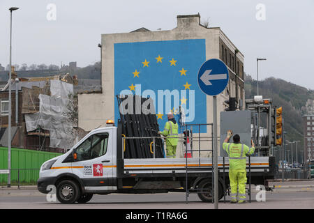 Dover, Großbritannien. 28. März 2019. Die Arbeiter im Hafen von Dover, Kent heute Schilder für Not verkehrsbezogene Maßnahmen in der Stadt vor dem Brexit Ergebnis. Ironicly direkt vor der Bankys Wandbild mit einem Star aus der EU-Flagge gekratzt wird. Credit: Nigel Bowles/Alamy leben Nachrichten Stockfoto